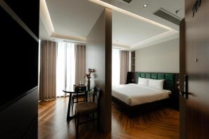 a bedroom with a bed and a table and a mirror at TQ Luxury Hotel & Apartment in An Khê +36 photos