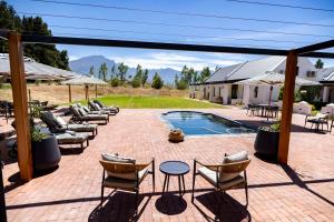 un patio con sedie a sdraio e una piscina di Diggers Country House a Tulbagh