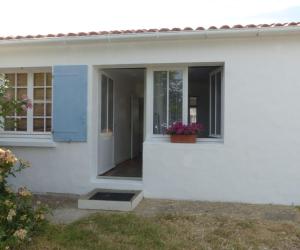 a white house with a window and a flower pot at Séjour indépendant et autonome chez l'habitant avec petit-déjeuner inclus in L'Ile d'Yeu