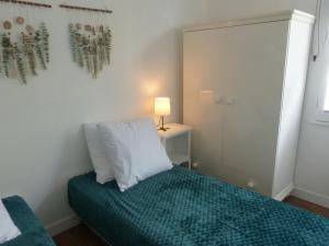 a bedroom with a bed with a pillow and a lamp at Séjour indépendant et autonome chez l'habitant avec petit-déjeuner inclus in L'Ile d'Yeu