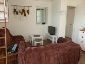 a living room with a couch and a tv at Séjour indépendant et autonome chez l'habitant avec petit-déjeuner inclus in L'Ile d'Yeu