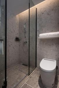 Huanman Hotel Changsha Yuelushan Yingwan Town Metro Station Branch في تشانغشا: حمام مزود بمرحاض ودش زجاجي