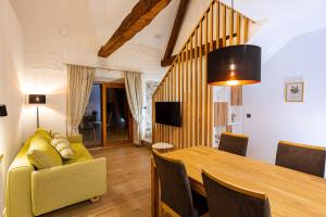 un soggiorno con tavolo e divano giallo di Resort Village Majer - Bela krajina a Gradac