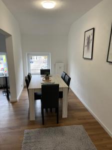 鲁尔河畔米尔海姆Ferienwohnung Ruhrperle的餐厅里有一张桌子和几把椅子