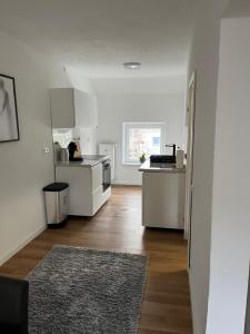 鲁尔河畔米尔海姆Ferienwohnung Ruhrperle的厨房配有白色橱柜和木地板 更多5张照片