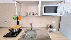 a kitchen with a sink and a microwave at Maya Suite & Garden in Sarteano +2 photos