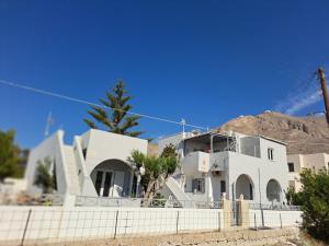 a white house with a mountain in the background at Studio Mimika in Perissa