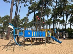 plac zabaw na piasku, na którym bawią się ludzie w obiekcie MH 480 2ch 2sdb 40m2 dans camping 4 étoiles avec parc aquatique w mieście Saint-Julien-en-Born