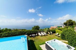 a view of a pool with chairs and a swimming pool at Estate4home - Villa Luisa Jacuzzi&Pool in SantʼAgata sui Due Golfi