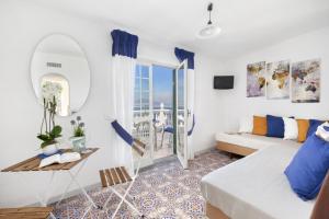 a white living room with a couch and a window at Estate4home - Villa Luisa Jacuzzi&Pool in SantʼAgata sui Due Golfi