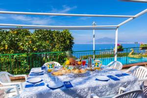 a table with food on a balcony with the ocean at Estate4home - Villa Luisa Jacuzzi&Pool in SantʼAgata sui Due Golfi