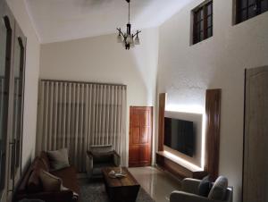 a living room with a couch and a tv at Melkbos Corner in eMalahleni