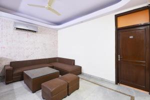 a living room with a couch and a door at FabHotel South Paradise in New Delhi