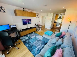 a living room with a blue couch and a television at WindyS Smart Home, you will love it in Basildon