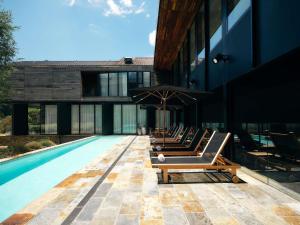 a row of lounge chairs next to a swimming pool at Peppers Marysville in Marysville
