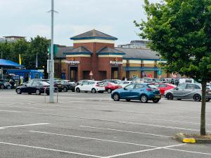a parking lot with cars parked in front of a store at WindyS Smart Home, you will love it in Basildon