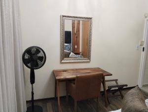 a room with a table and a mirror and a fan at Melkbos Corner in eMalahleni +1 photo