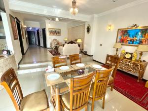 een woonkamer met een tafel, stoelen en een bank bij Beautiful Apartment in Islamabad