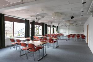 uma fileira de mesas e cadeiras em uma sala com janelas em Best Western Hotell Kramm em Kramfors