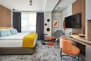 a hotel room with a bed and a desk at voco Katowice by IHG in Katowice