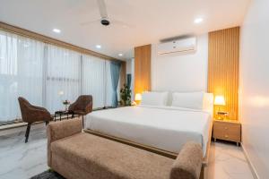 a bedroom with a large white bed and a couch at Rcc Hotels Gachibowli in Hyderabad
