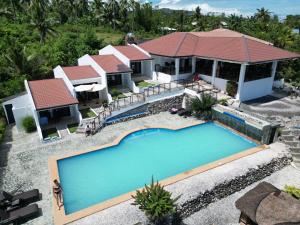 Panorama de Argao Boutique Hotel في Argao: منظر جوي لمنزل به حوض سباحة