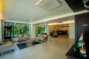 una amplia sala de estar con sofás y una mesa en Krishna Inn - Royal Hotels, en Kolhapur