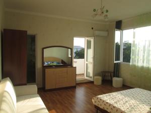 a bedroom with a dresser with a mirror and a bed at Lily Pearls Inn in Kobuleti