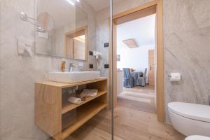 a bathroom with a sink and a glass shower at Ciasa Nene Franzl in Badia +40 photos