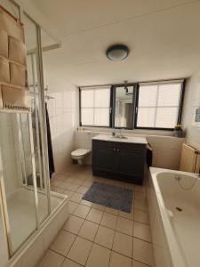 a bathroom with a tub and a toilet and a sink at Villa Julia 148 in Callantsoog +10 photos