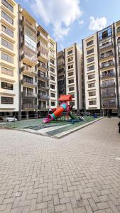 a playground in front of some apartment buildings at Comfort meets convenience 3BR by Airport & SGR in Nairobi