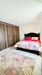 a bedroom with a large bed with red pillows at Comfort meets convenience 3BR by Airport & SGR in Nairobi +5 photos