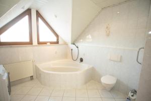 HopfmannsfeldFerienwohnung Heike的带浴缸和马桶的白色浴室 更多14张照片
