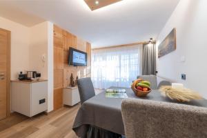 a room with a table with a bowl of fruit on it at Ciasa Nene Franzl in Badia