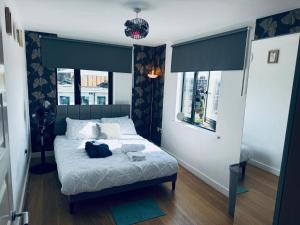 a bedroom with a bed and two windows at WindyS Smart Home, you will love it in Basildon