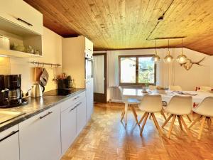 Una cocina con gabinetes blancos y una mesa y sillas. en Sonnes Apartment, en Andelsbuch 68 fotos más