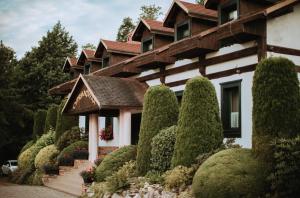 a house with a row of trees in front of it at Cyprianówka in Warszowice