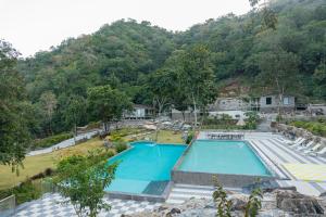 uma vista superior de uma piscina com uma montanha em Treat Aranya Resort Kumbhalgarh em Kumbhalgarh