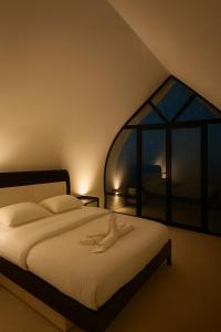 BadīyahにあるGalaxy chaletのベッドと大きな窓のある寝室