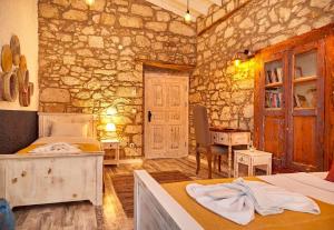 阿拉恰特MorisiAvluAlaçatı的一间带床和石墙的卧室