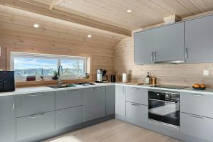 a kitchen with white cabinets and a window at Modern Mountain Cabin Near Norefjell in Eggedal