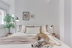 a white bedroom with a bed with a basket on it at Main Street Deluxe in A Coruña