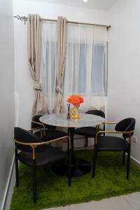 a table with two chairs and a vase with flowers at Martha House New BELL Douala in Douala +33 photos