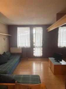 a living room with a couch and two windows at Condominio La Grand'Ourse - Cervinia in Breuil-Cervinia
