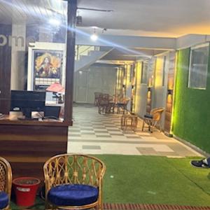 博瓦利Sk inn hotel的一条摆放着椅子、铺着绿色地板的走廊和一个房间