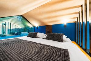 una camera da letto con un letto grande con pareti blu di Ostravinka - Boutique Cabin a Ostrava