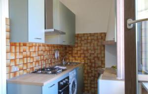 Serra deʼ ContiNice Home In Serra Dè Conti With Wifi的带水槽和炉灶的厨房 顶部烤箱