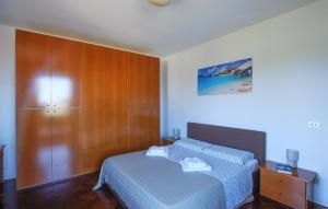 Serra deʼ ContiNice Home In Serra Dè Conti With Wifi的带床和木柜的卧室