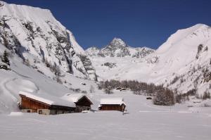 a snow covered mountain with a cabin in the foreground at Gästehaus Tinkl in Kals am Großglockner