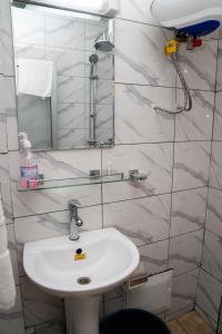 um banheiro com uma pia e um espelho em Martha House Bonapriso Douala em Douala mais 33 fotografias